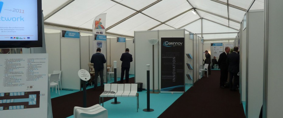 Salon professionnel avec exposants et stands modulaires de différentes dimensions en mélaminé, avec moquette